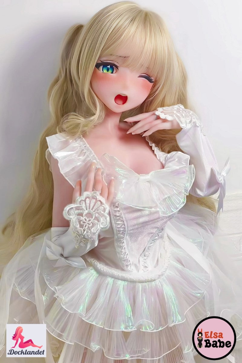 Ichigotani Koi 140 cm silikonsexdocka från ElsaBabe, ligger på rosa säng i vit volangklänning, blont hår och blinkande animeögon.
